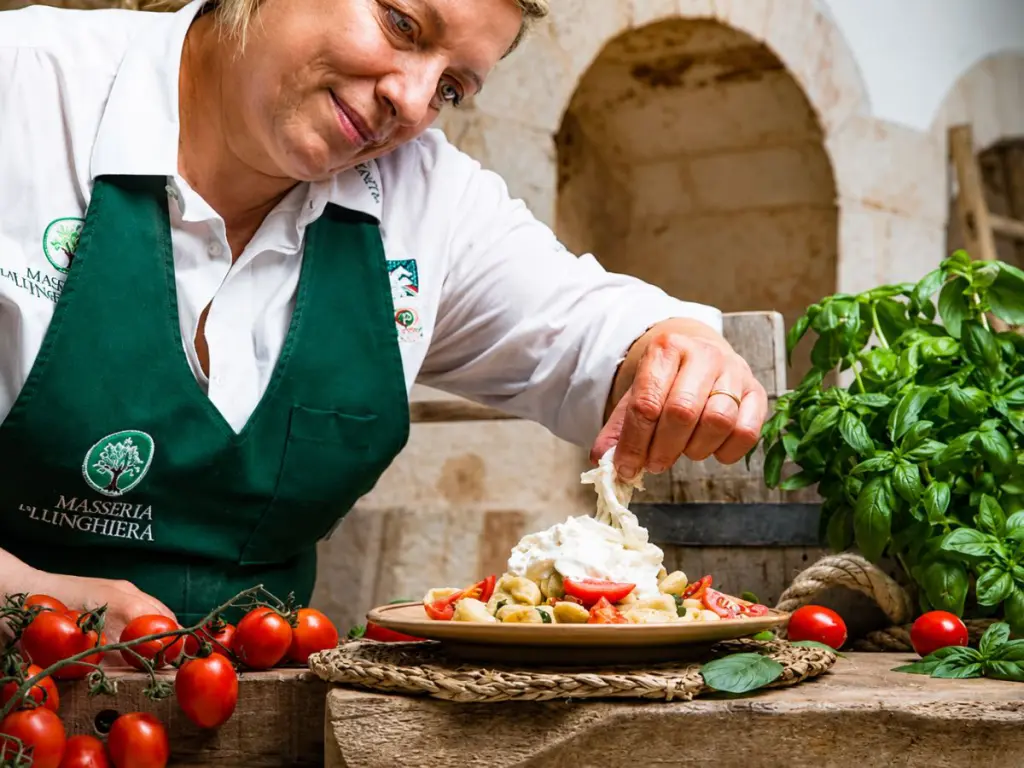 Casara che apre una burrata artigianale appena fatta in un caseificio pugliese