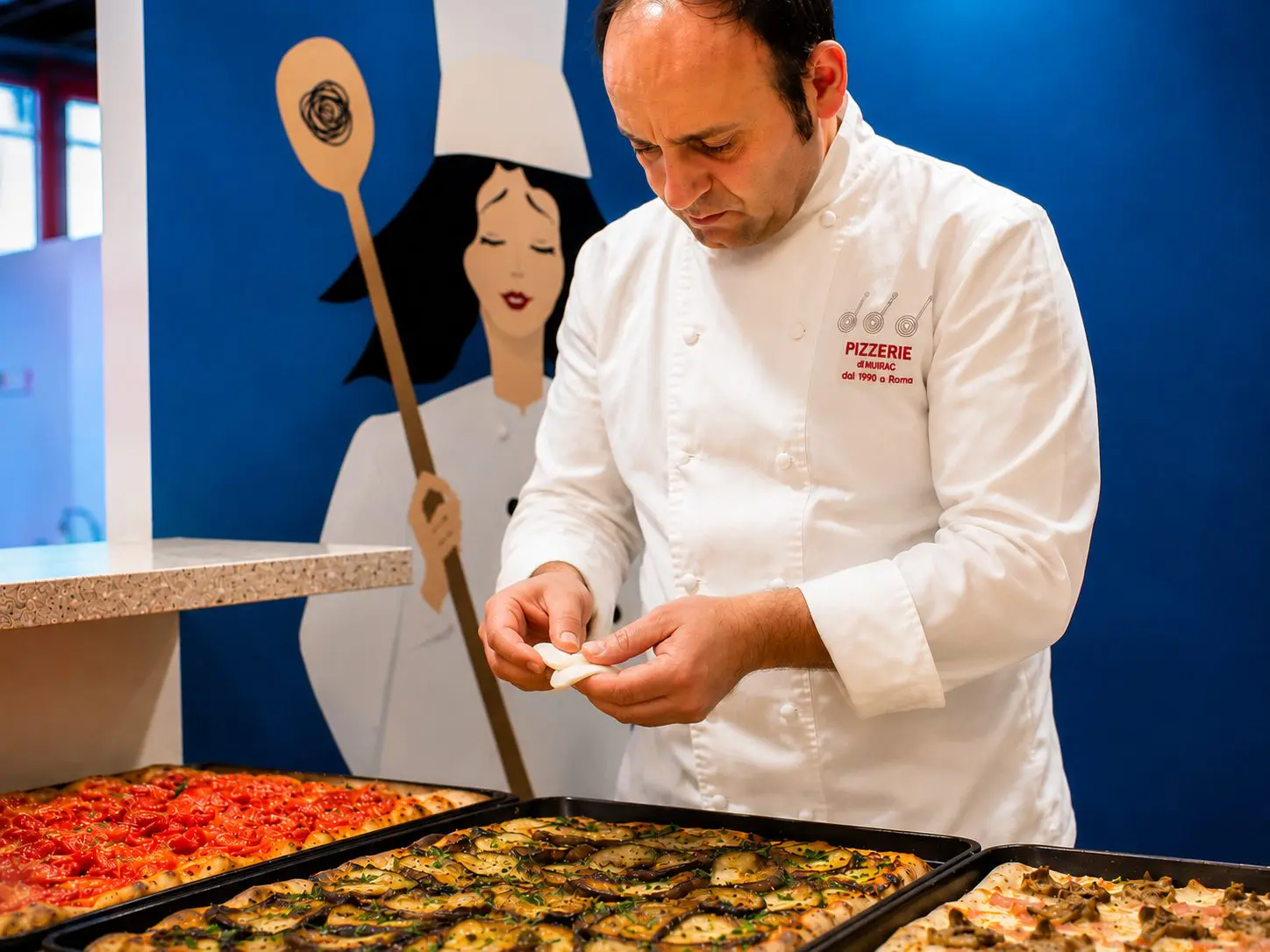 Antonio Oliva nel laboratorio della sua pizzeria ad Acri con alcune pizze al taglio contemporanee