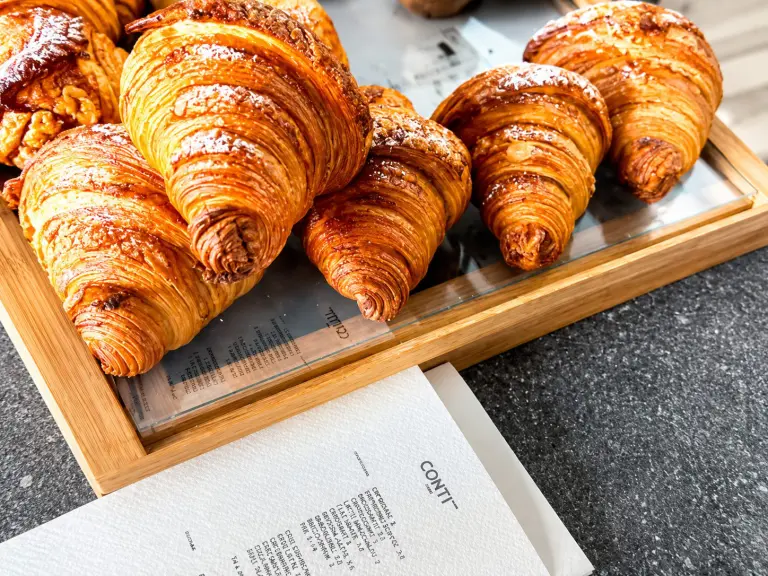 Interno di Cafè Conti & Co. all'Esquilino con il bancone dei lievitati e la caffetteria specialty