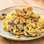 Piatto di curzul romagnoli con vongole e pangrattato tostato