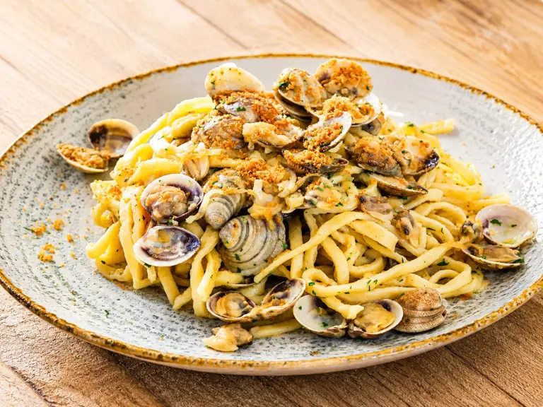Piatto di curzul romagnoli con vongole e pangrattato tostato