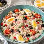 Insalata di riso con pomodori, prosciutto cotto, olive, uova sode