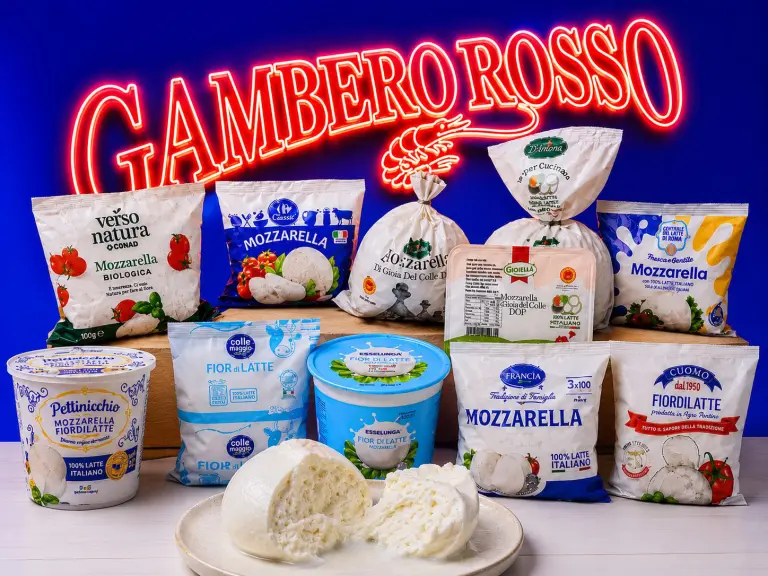 Una mano sceglie una confezione di mozzarella fior di latte dal banco frigo di un supermercato italiano