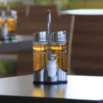Oliera trasparente e rabboccabile sul tavolo di un ristorante