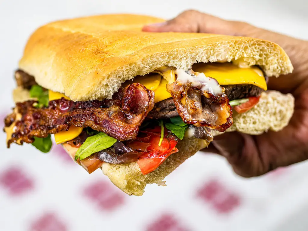 Panino extralarge con hamburger e patatine servito al Saloon del Panino sulla Portuense a Roma