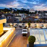 Piatto di pesce crudo sulla terrazza panoramica AcquaRoof con vista sul centro storico di Roma al tramonto
