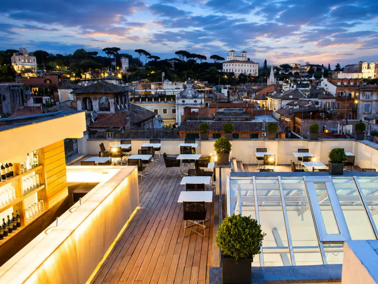 Piatto di pesce crudo sulla terrazza panoramica AcquaRoof con vista sul centro storico di Roma al tramonto