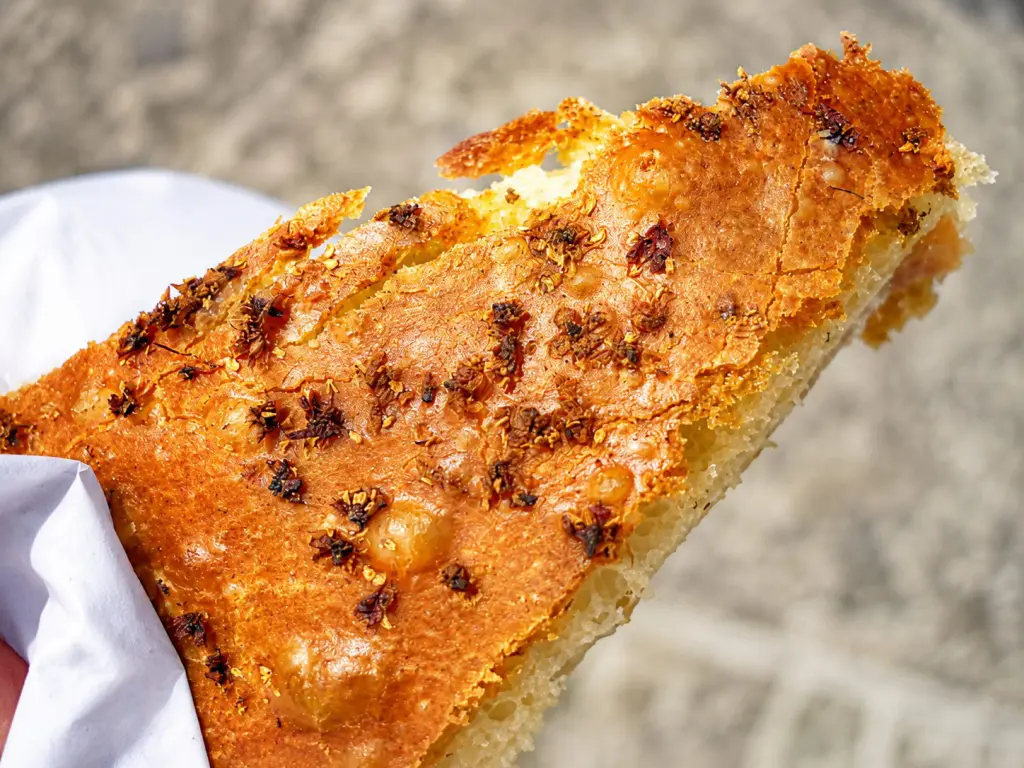 Vastedda cu samucu di Troina, la tradizionale focaccia siciliana ripiena di tuma, salame e guanciale con fiori di sambuco nell'impasto