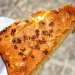 Vastedda cu samucu di Troina, la tradizionale focaccia siciliana ripiena di tuma, salame e guanciale con fiori di sambuco nell'impasto
