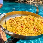 Preparazione di un piatto di pasta sul ponte di una barca in mare
