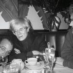 Foto in bianco e nero di Andy Warhol e Keith Haring a tavola