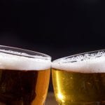 Due bicchieri di birra che brindano visti a metà