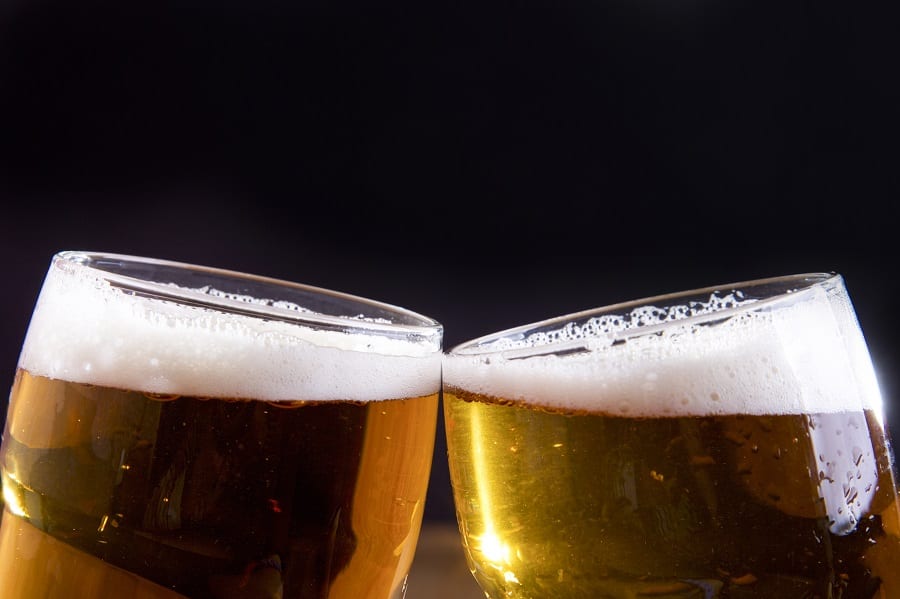 Due bicchieri di birra che brindano visti a metà