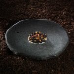 Un piatto di Rodolfo Guzman, su pietra nera e terra