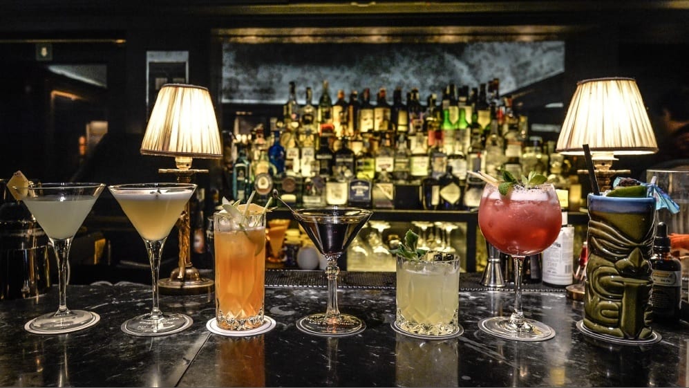 Una serie di cocktail sul bancone di un bar