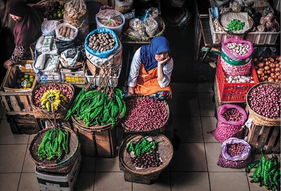 Donna islamica che vende frutta e verdura al mercato