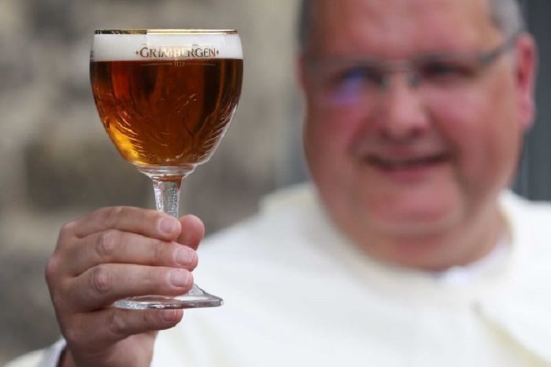 Un monaco tiene in mano un calice di birra