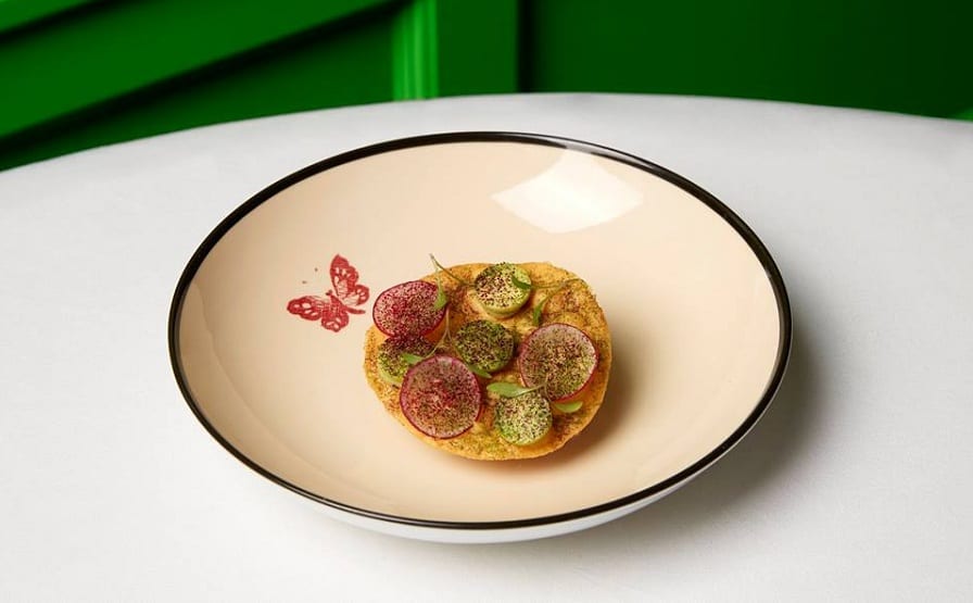 La tostada di Gucci Osteria, su piatto in porcellana con farfalla dipinta