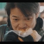 Kotaro Noda addenta una specialità di street food
