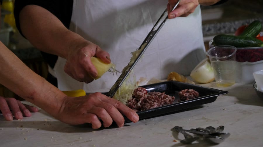 Preparazione dei sinya, sfiziosi bocconcini di carne ricoperti di salsa tahina