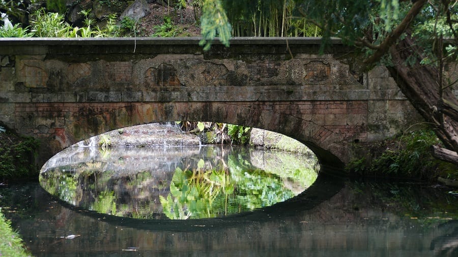 Il giardino della Reggia di Caserta: ponte che si riflette in uno specchio d'acqua