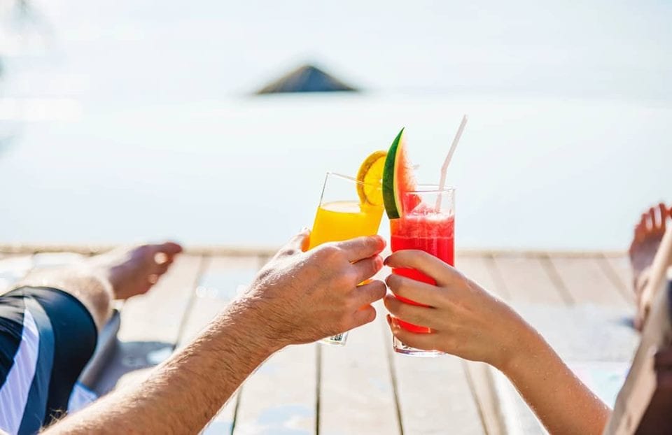 Brindisi in riva al mare, con due cocktail tropicali