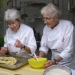 Le sorelle Simili al lavoro con un impasto in cucina