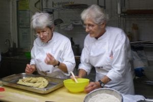 Le sorelle Simili al lavoro con un impasto in cucina