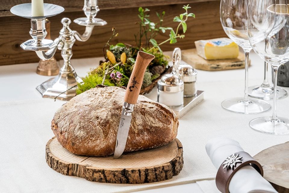 La tavola di Marc Veyrat a La Maison de Bois, con pane sul tagliere in legno e coltello firmato dallo chef