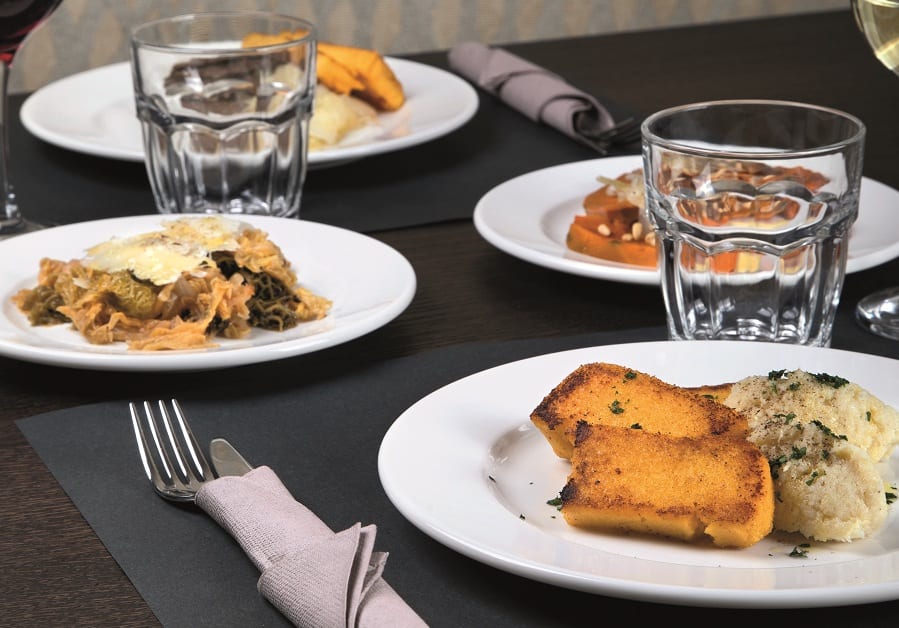 Quattro piatti di cicheti sul tavolo di Tàscaro, con polenta e baccalà mantecato, e fegato alla veneziana